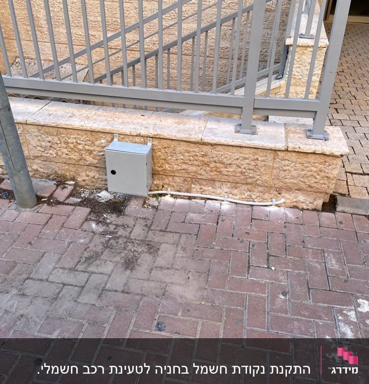 קופסת חשמל אפורה מותקנת על קיר אבן
